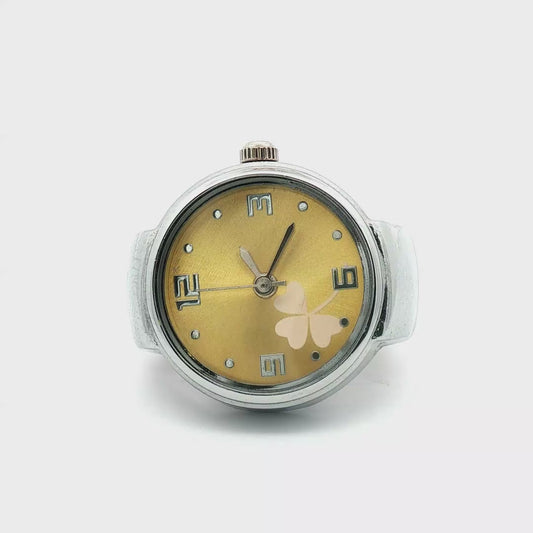 Anillo reloj dorado con diseño de trébol.